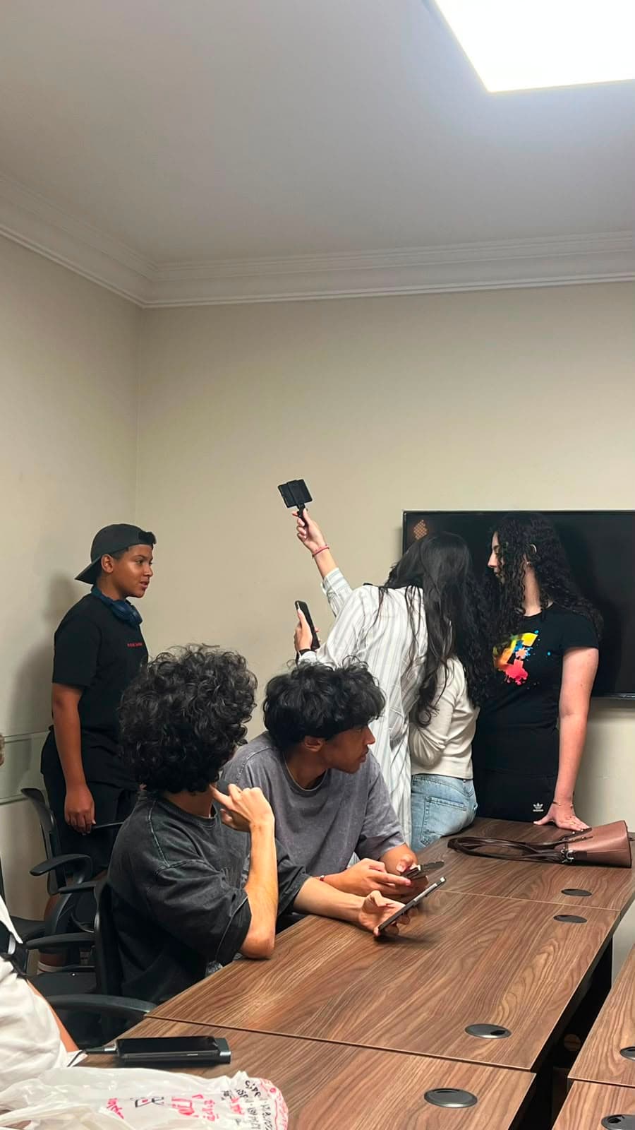 Crew using a handheld LED light while shooting video