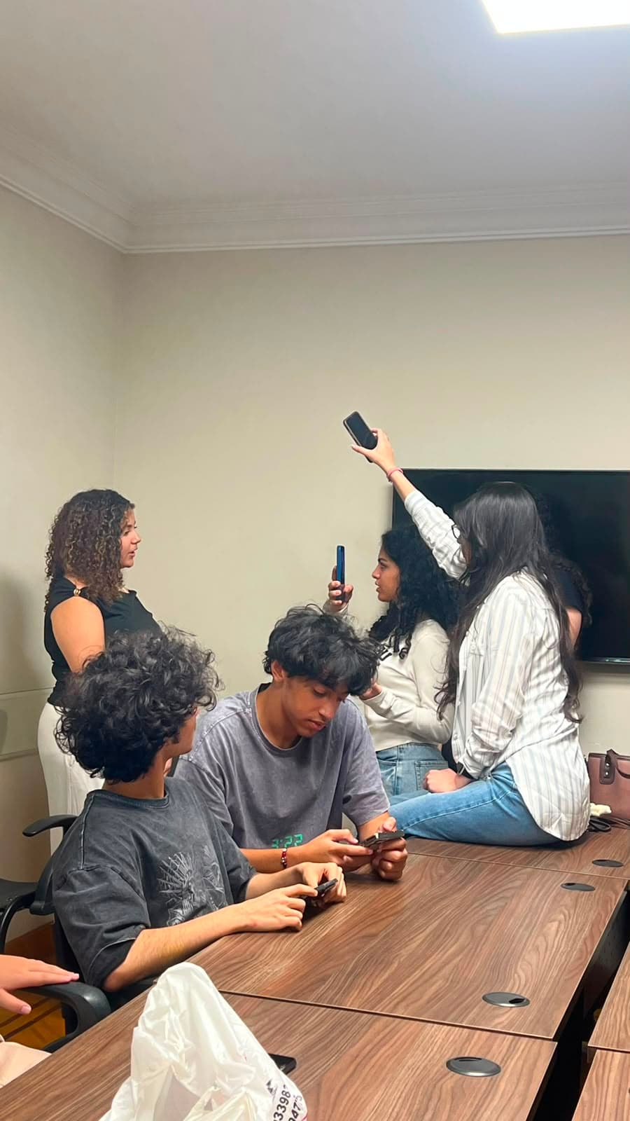 Members capturing photos and video around the conference table
