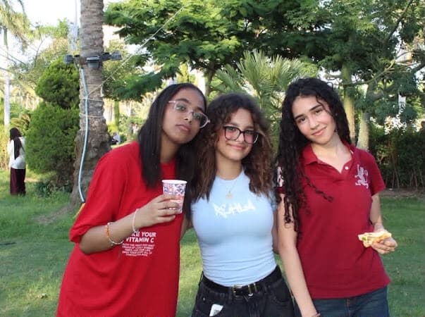 Three members at the park picnic, one holding a cup